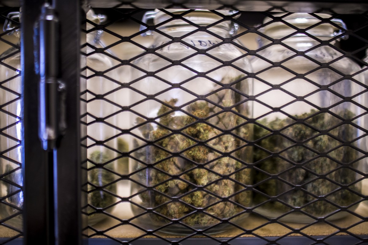 Jars of medical marijuana are kept locked behind a metal gate in a dispensary in Missoula, Montana. Martin do Nascimento/News21